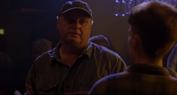 Movie still from “Boys Don't Cry” (1999), directed by Kimberly Peirce – A man wearing a hat standing next to another man in a room; Close Up shot, Over the shoulder angle