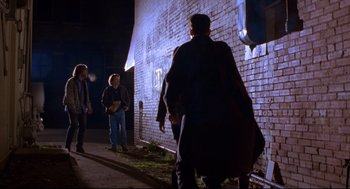 Movie still from “Boys Don't Cry” (1999), directed by Kimberly Peirce – A group of people standing next to a brick wall; Wide shot, Low angle