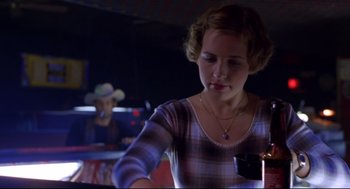 Movie still from “Boys Don't Cry” (1999), directed by Kimberly Peirce – A woman in a plaid shirt is holding a candle; Medium shot, Low angle