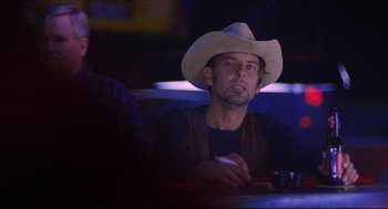 Movie still from “Boys Don't Cry” (1999), directed by Kimberly Peirce – A man in a cowboy hat sitting at a table in a restaurant; Close Up shot, Over the shoulder angle