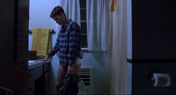 Movie still from “Boys Don't Cry” (1999), directed by Kimberly Peirce – A young man in a blue flannel shirt and white shorts; Medium shot, High angle