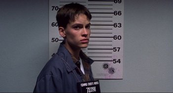 Movie still from “Boys Don't Cry” (1999), directed by Kimberly Peirce – A young man in a police uniform standing in front of a wall; Close Up shot, Low angle