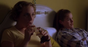 Movie still from “Boys Don't Cry” (1999), directed by Kimberly Peirce – A woman sitting in front of another woman holding a soda; Close Up shot, High angle