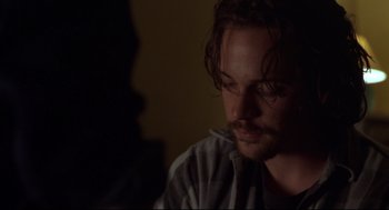 Movie still from “Boys Don't Cry” (1999), directed by Kimberly Peirce – A person sitting in a dark room; Close Up shot, Over the shoulder angle