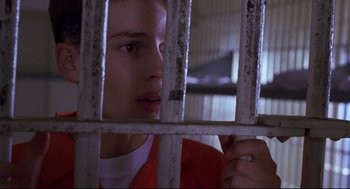 Movie still from “Boys Don't Cry” (1999), directed by Kimberly Peirce – A young man looking through a jail cell bars; Close Up shot, Low angle