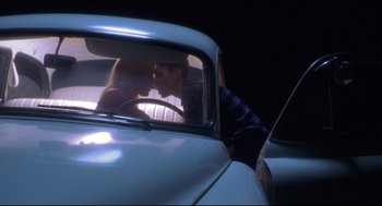 Movie still from “Boys Don't Cry” (1999), directed by Kimberly Peirce – A man and a woman kissing in the back of a car; Medium shot, High angle