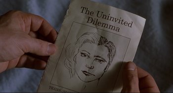 Movie still from “Boys Don't Cry” (1999), directed by Kimberly Peirce – A hand holding a book with a drawing of a woman's face on it; Extreme Close Up shot, Overhead angle