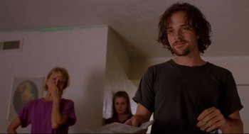 Movie still from “Boys Don't Cry” (1999), directed by Kimberly Peirce – A man standing next to two women in a room; Medium shot, Low angle