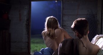 Movie still from “Boys Don't Cry” (1999), directed by Kimberly Peirce – A man and a woman sitting in front of an open door; Medium shot, Over the shoulder angle