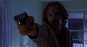 Movie still from “Boys Don't Cry” (1999), directed by Kimberly Peirce – A man holding a gun in a room; Close Up shot, Low angle