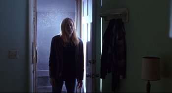 Movie still from “Boys Don't Cry” (1999), directed by Kimberly Peirce – A woman standing in front of an open door; Medium shot, Low angle
