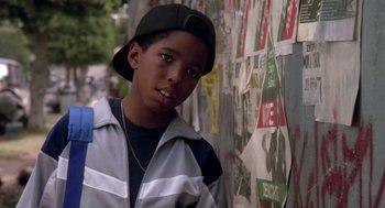 Movie still from “Boyz n the Hood” (1991), directed by John Singleton – A young boy standing in front of a wall covered in stickers; Close Up shot, Low angle