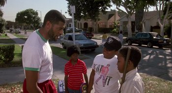 Movie still from “Boyz n the Hood” (1991), directed by John Singleton – A group of young men standing on the side of a road; Medium shot, Over the shoulder angle