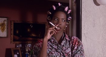 Movie still from “Boyz n the Hood” (1991), directed by John Singleton – A woman with curlers in her hair is smoking a cigarette; Close Up shot, Low angle