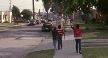 Movie still from “Boyz n the Hood” (1991), directed by John Singleton – Three boys walking down the sidewalk of a residential street; Extreme Wide shot, High angle