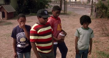 Movie still from “Boyz n the Hood” (1991), directed by John Singleton – A group of young people standing next to each other on a dirt field; Medium shot, Low angle