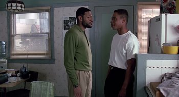 Movie still from “Boyz n the Hood” (1991), directed by John Singleton – Two young men standing next to each other in front of a door; Medium shot, Over the shoulder angle