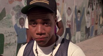 Movie still from “Boyz n the Hood” (1991), directed by John Singleton – A young man wearing a baseball cap and a white shirt; Close Up shot, Over the shoulder angle