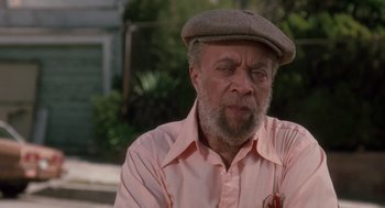 Movie still from “Boyz n the Hood” (1991), directed by John Singleton – An older man wearing a hat and a pink shirt; Close Up shot, Low angle