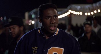 Movie still from “Boyz n the Hood” (1991), directed by John Singleton – A person wearing a baseball uniform; Close Up shot, High angle