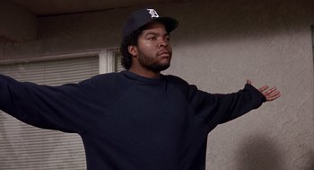 Movie still from “Boyz n the Hood” (1991), directed by John Singleton – A man in a baseball hat and a sweatshirt; Medium shot, Low angle