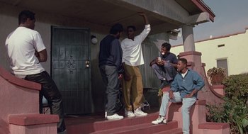 Movie still from “Boyz n the Hood” (1991), directed by John Singleton – A group of young men standing on steps in front of a building; Wide shot, High angle
