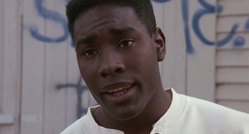 Movie still from “Boyz n the Hood” (1991), directed by John Singleton – A person wearing a white t - shirt; Close Up shot, High angle
