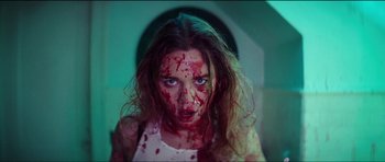 A woman with blood all over her face and neck