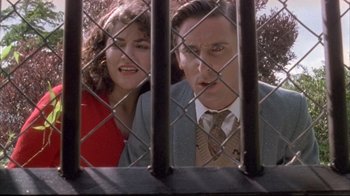 Movie still from “Dead Alive” (1992), directed by Peter Jackson – A man and a woman behind a chain link fence; Close Up shot, Low angle