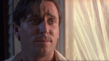 Movie still from “Dead Alive” (1992), directed by Peter Jackson – A man's face in front of a window; Close Up shot, Low angle