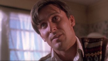 Movie still from “Dead Alive” (1992), directed by Peter Jackson – A person with short brown hair; Close Up shot, Low angle