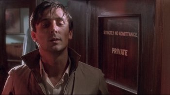 Movie still from “Dead Alive” (1992), directed by Peter Jackson – A man that is standing in front of a wall; Close Up shot, Low angle