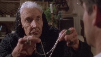 Movie still from “Dead Alive” (1992), directed by Peter Jackson – An old woman holding a rosary in her hands; Close Up shot, Low angle
