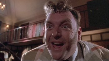 Movie still from “Dead Alive” (1992), directed by Peter Jackson – A person wearing a suit and tie; Close Up shot, Low angle