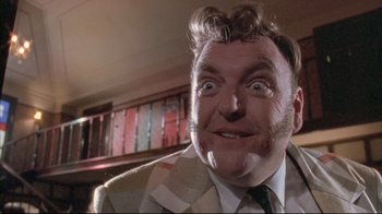 Movie still from “Dead Alive” (1992), directed by Peter Jackson – A person wearing a suit and tie; Close Up shot, Low angle