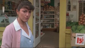 Movie still from “Dead Alive” (1992), directed by Peter Jackson – A woman standing in front of a store doorway; Close Up shot, Over the shoulder angle