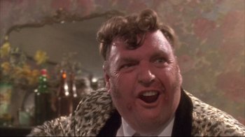 Movie still from “Dead Alive” (1992), directed by Peter Jackson – A person wearing a suit and tie; Close Up shot, Low angle