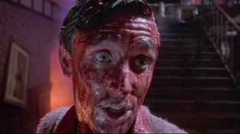 Movie still from “Dead Alive” (1992), directed by Peter Jackson – A person with blood all over his face; Close Up shot, High angle