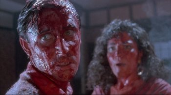 Movie still from “Dead Alive” (1992), directed by Peter Jackson – A man and a woman are covered in fake blood; Close Up shot, Low angle