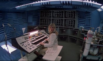 Movie still from “Brainstorm” (1983), directed by Douglas Trumbull – A woman sitting in front of an electronic keyboard; Wide shot, High angle