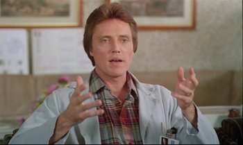 Movie still from “Brainstorm” (1983), directed by Douglas Trumbull – A man in a white lab coat talking to a camera; Close Up shot, Low angle