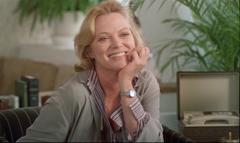 Movie still from “Brainstorm” (1983), directed by Douglas Trumbull – A woman sitting in front of a plant smiling for the camera; Close Up shot, Low angle