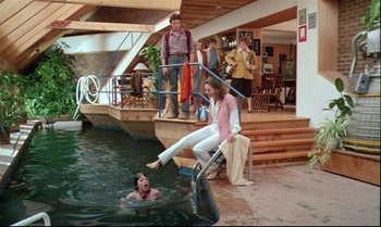 Movie still from “Brainstorm” (1983), directed by Douglas Trumbull – A woman sitting on a chair next to a man in a swimming pool; Wide shot, High angle