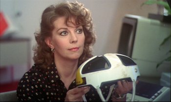 Movie still from “Brainstorm” (1983), directed by Douglas Trumbull – A woman is holding a soccer helmet in her hands; Close Up shot, Over the shoulder angle