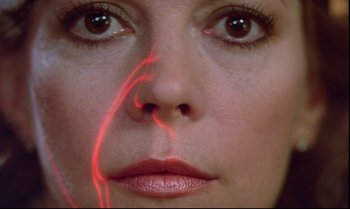 Movie still from “Brainstorm” (1983), directed by Douglas Trumbull – A woman's face with red lines coming out of her mouth; Extreme Close Up shot, Overhead angle