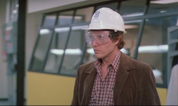 Movie still from “Brainstorm” (1983), directed by Douglas Trumbull – A man wearing a white hard hat and glasses; Medium shot, Low angle