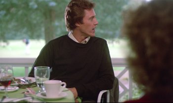 A man sitting at a table in front of a cup of coffee