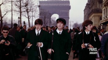 Movie still from “The Beatles: Eight Days a Week - The Touring Years” (2016), directed by Ron Howard – A group of young men walking down a street; Medium shot, Low angle