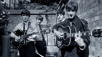 Movie still from “The Beatles: Eight Days a Week - The Touring Years” (2016), directed by Ron Howard – A group of young men holding guitars in a brick wall; Medium shot, Low angle