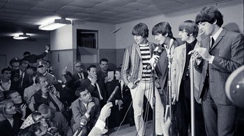 Movie still from “The Beatles: Eight Days a Week - The Touring Years” (2016), directed by Ron Howard – A black and white photo of a group of young men; Medium shot, High angle